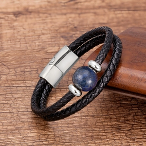 Detail of double-layer black woven leather bracelet with blue stone and magnetic clasp