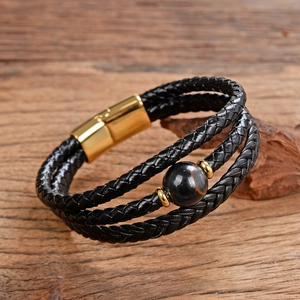 Dettaglio macro del bracciale multistrato in pelle intrecciata con chiusura magnetica dorata