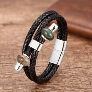 Dettaglio di un bracciale in pelle intrecciata con chiusura magnetica e perle in pietra