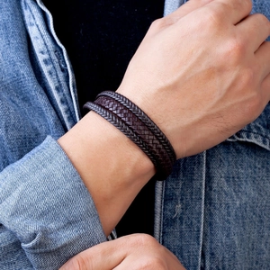 Multi-layer woven leather bracelet for men with magnetic clasp on denim background