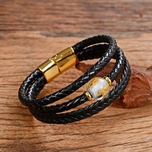 Dettaglio del bracciale in pelle intrecciata multistrato con chiusura magnetica dorata