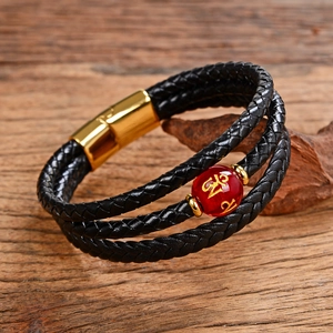 Dettaglio bracciale multistrato in pelle nera intrecciata con perla rossa e chiusura magnetica