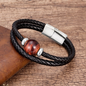 Detail showing the red-brown tiger eye stone and silver magnetic clasp on a braided leather band