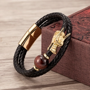 Detailed close-up of golden dragon head with tiger eye bead on double braided leather bracelet