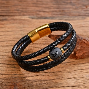 Dettaglio del bracciale multistrato in pelle nera con chiusura magnetica dorata e perla