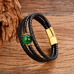 Dettaglio del bracciale multistrato in pelle intrecciata con pietra verde e chiusura magnetica