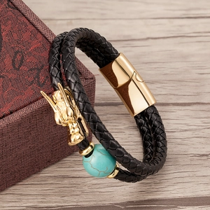 Detailed view of black braided leather bracelet with golden dragon head and turquoise bead