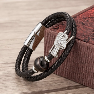 Detail of double-layer black leather bracelet with silver dragon head and tiger eye stone