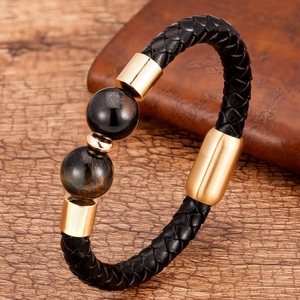 Dettaglio bracciale da uomo in pelle nera con chiusura magnetica dorata e perline in pietra