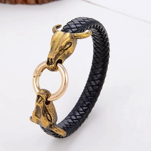 Detail of men's black braided leather bracelet with two gold bull head metal accents