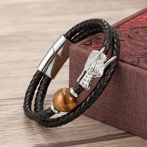 Close-up of a double-layer black leather bracelet with a silver dragon head and tiger eye stone