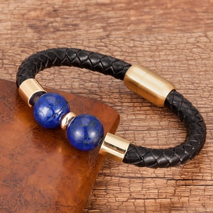 Dettaglio del bracciale da uomo in pelle nera con perle blu e chiusura magnetica dorata