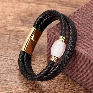 Detail showing black braided leather bracelet with pink stone and gold magnetic clasp
