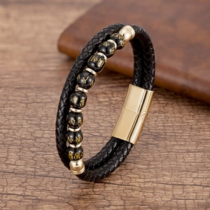 Details des geflochtenen Lederarmbands mit Goldverschluss und schwarzen Perlen