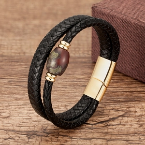 Detail of leather woven bracelet with red stone bead and golden magnetic clasp