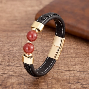 Détail du bracelet en cuir tressé à double couche avec perles rouges et fermoir doré