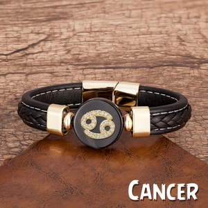 Détail macro du bracelet en cuir tressé signe Cancer avec fermoir doré poli