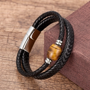 Close-up of handmade leather braided bracelet featuring a tiger eye stone and magnetic clasp