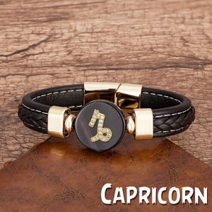 Détail du bracelet Capricorne en cuir tressé avec fermoir magnétique doré sur bois