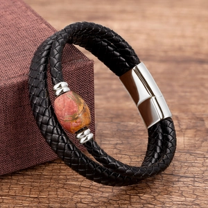 Macro detail of men's leather cord bracelet with red natural stone and magnetic buckle