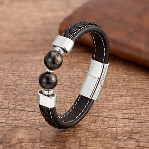Détail du bracelet en cuir tressé noir avec pierres oeil de tigre et fermoir magnétique