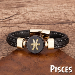 Détail du charme signe astro Poissons sur bracelet en cuir tressé noir et fermoir doré