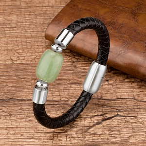 Detail view of woven black leather bracelet with rectangular green stone and metal clasp