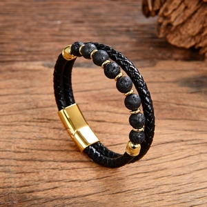 Detailed close-up of men's leather bracelet with lava stone beads and gold magnetic clasp