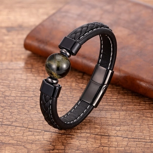Détail d'un bracelet en cuir tressé noir avec pierre oeil de tigre et fermoir magnétique