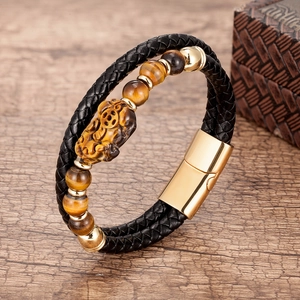 Détail du charm Pixiu en œil de tigre sur bracelet double couche en cuir noir tressé