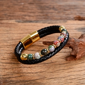 Detail of black braided leather bracelet with multi-color stone beads and gold magnetic clasp