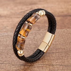 Detailed macro of layered leather bracelet featuring tiger eye stones and gold magnetic clasp