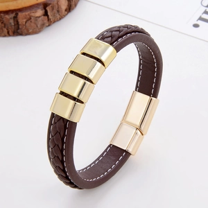Detail view of brown braided leather bracelet with gold metal blocks and magnetic clasp
