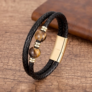 Détail du bracelet en cuir tressé noir avec perles oeil de tigre et fermoir magnétique doré