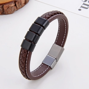 Close-up of brown braided leather bracelet with black square beads and magnetic metal clasp