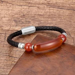 Detail of woven black leather bracelet with red agate beads and silver magnetic clasp
