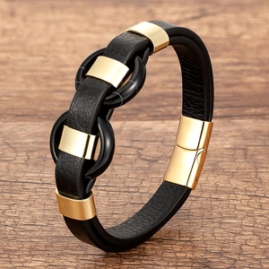 Détail macro du bracelet en cuir tressé noir avec tubes dorés et anneaux en pierre