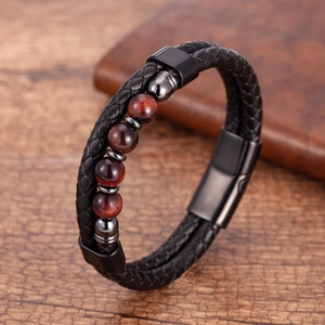 Dettaglio del bracciale in pelle intrecciata a doppio strato con perle occhio di tigre rosso e fibbia