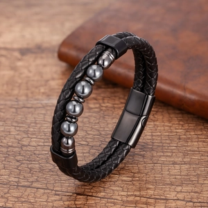 Dettaglio del bracciale in pelle intrecciata nera a doppio strato con perline di metallo grigie