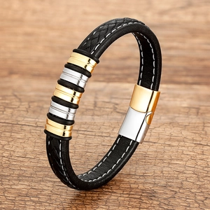 Detail of woven black leather bracelet featuring gold and silver magnetic metal clasp