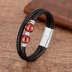 Gros plan d'un bracelet en cuir tressé double couche avec perles rouges et fermoir acier