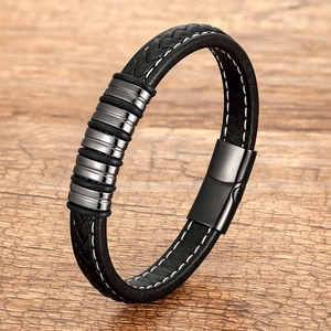 Braided black leather bracelet with stainless steel rings and magnetic clasp on wood