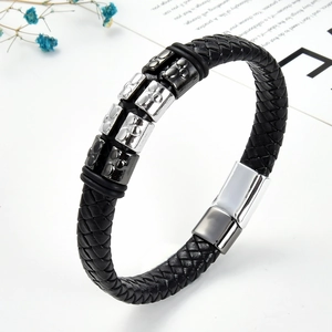 Macro shot of black braided leather bracelet with engraved square metal beads and magnetic clasp