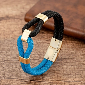 Detail of blue and black braided leather bracelet with polished gold metal clasp and links