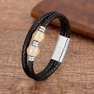 Détail du bracelet en cuir tressé pour homme avec perles mantra dorées et fermoir aimanté