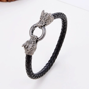 Dettaglio del bracciale in pelle nera intrecciata con fermagli a testa di drago in stile vintage