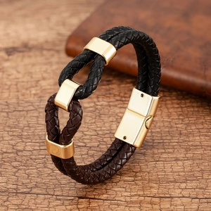 Detail of woven leather bracelet in black and chocolate with golden magnetic clasp