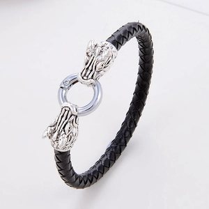 Dettaglio del bracciale in pelle nera intrecciata con chiusura a testa di drago d'argento