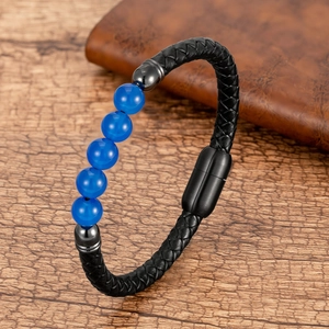 Vista macro detallada de pulsera de cuero negro trenzado con cinco cuentas de piedra azul oscuro