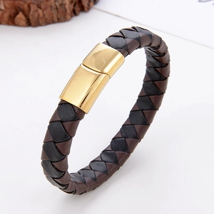 Detailopname van bruin en zwart gevlochten leren armband met gepolijste gouden magneetsluiting